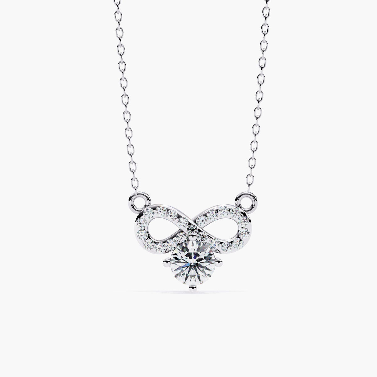 A white gold infinity necklace with a diamond solitaire stone under the infinity symbol.