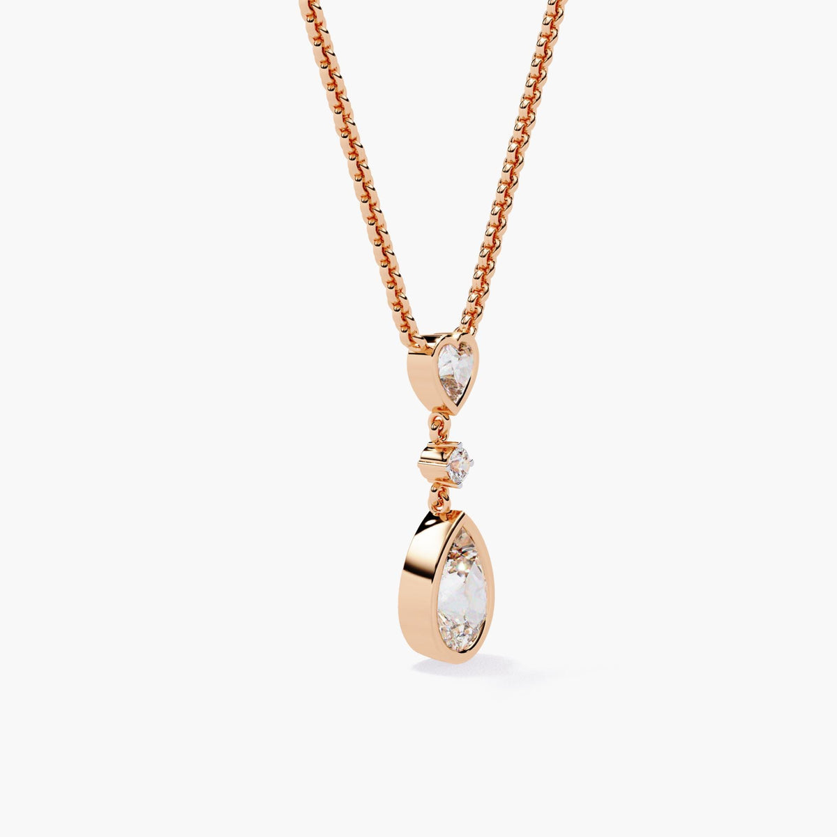 A rose gold chain necklace with a pear-shaped diamond pendant and a heart-shaped diamond accent.