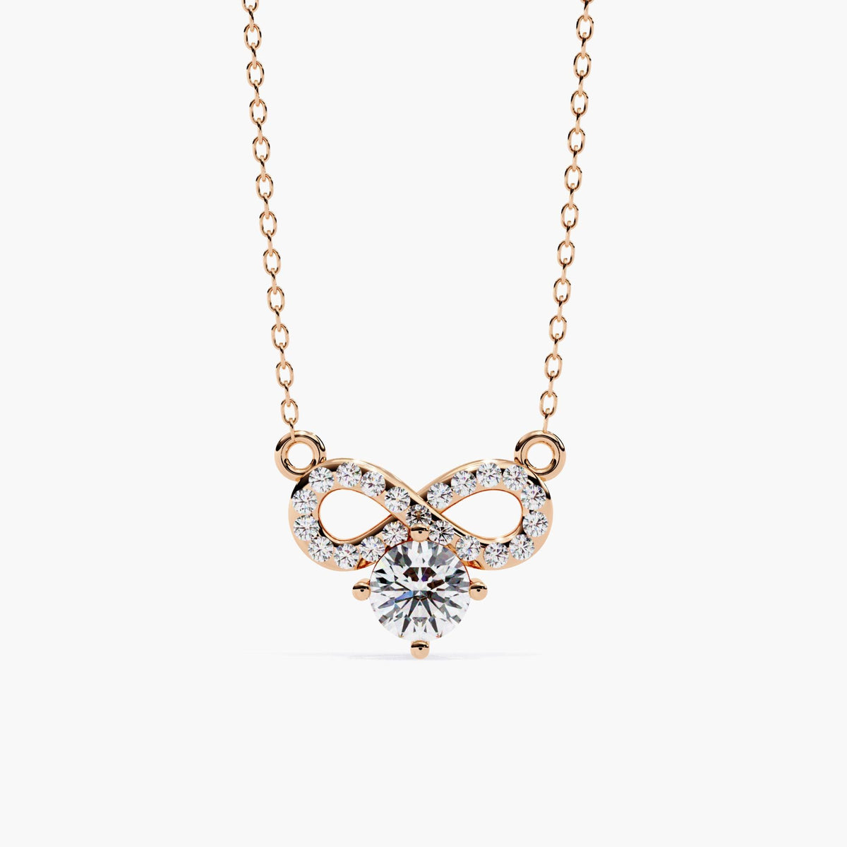 A gold infinity necklace with a diamond solitaire stone under the infinity symbol.
