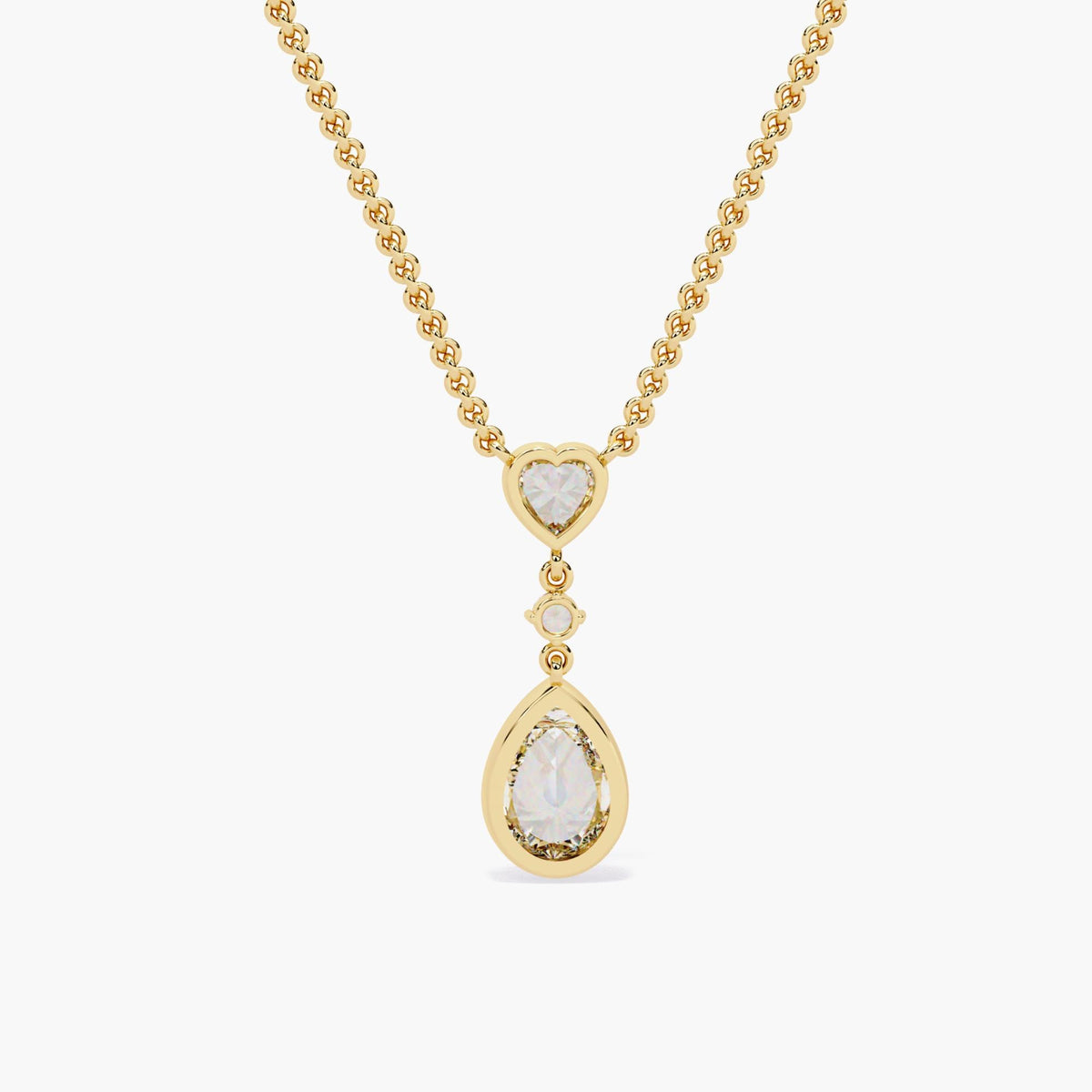 A gold chain necklace with a pear-shaped diamond pendant and a heart-shaped diamond accent.