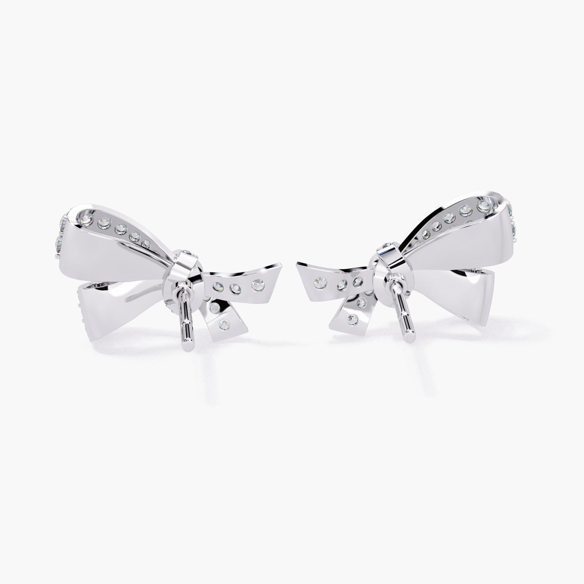 A pair of white gold earrings with a small bow design made of clear diamonds.