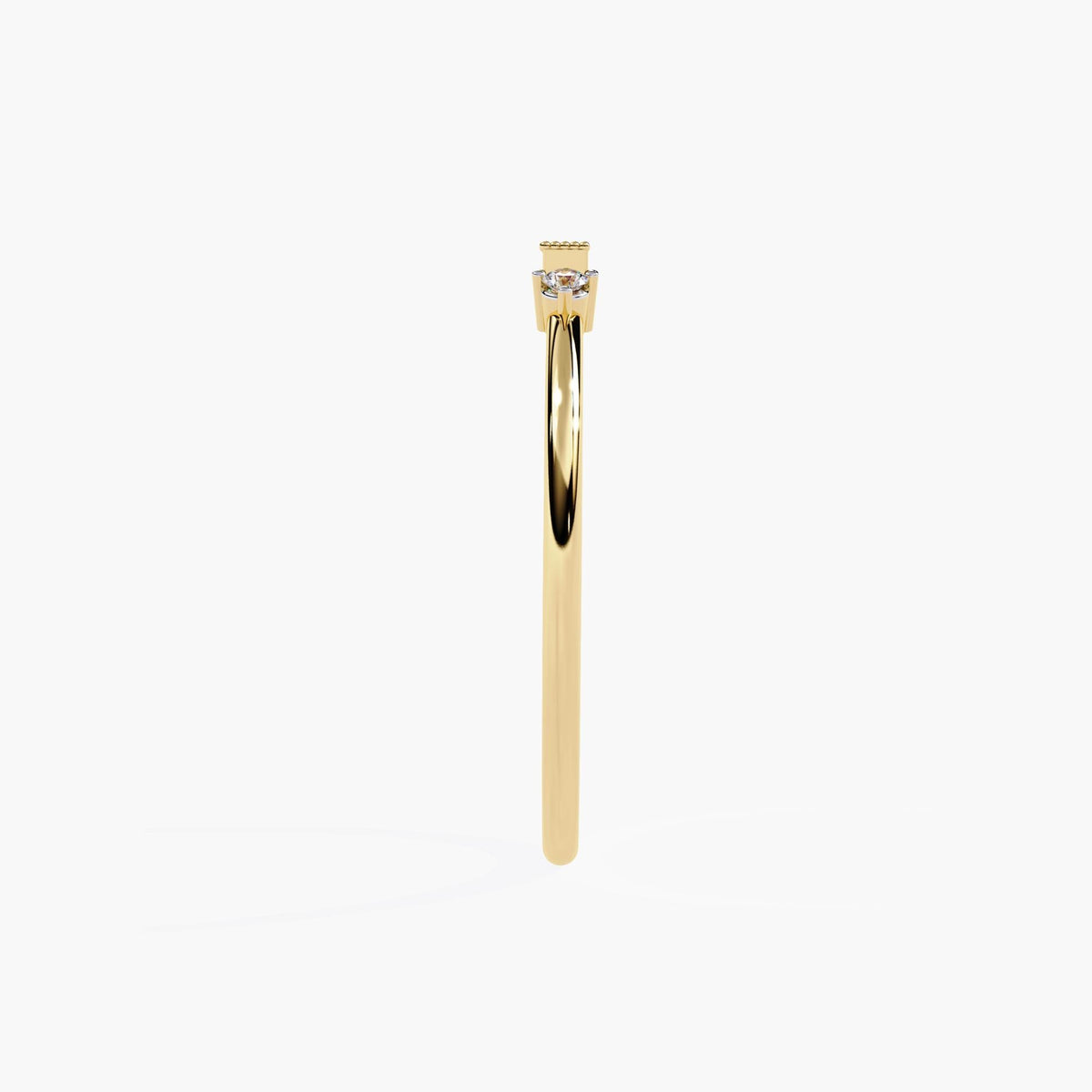 A yellow gold ring with three small diamonds. The center diamond is a baguette cut and the two diamonds on either side are round.