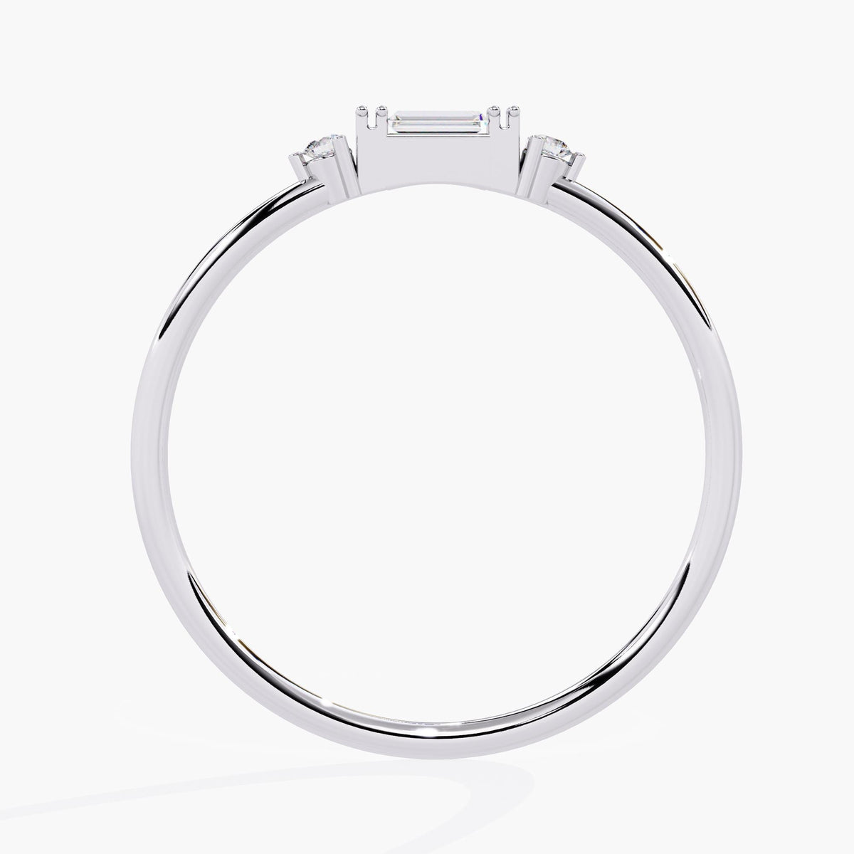 A white gold ring with three small diamonds. The center diamond is a baguette cut and the two diamonds on either side are round.