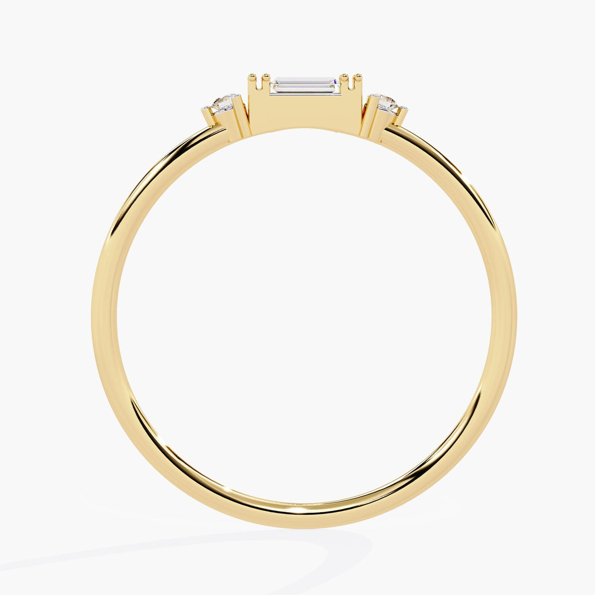 Back view of a 14K yellow gold ring with a baguette diamond center and round side stones, shown in a slim and minimalist band. A thoughtful promise ring or stacking band.