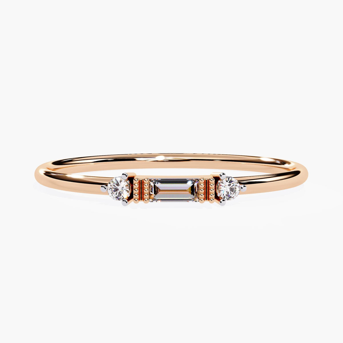 A rose gold ring with three small diamonds. The center diamond is a baguette cut and the two diamonds on either side are round.