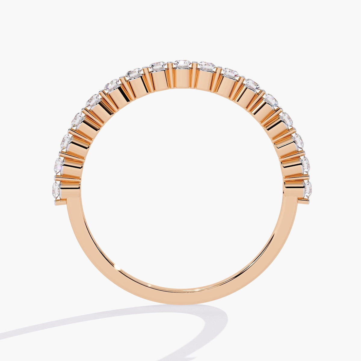 Side profile view of a half eternity diamond ring in 14k rose gold, highlighting the open gallery floating prong design that showcases each round lab-grown diamond while maintaining a clean and refined silhouette.