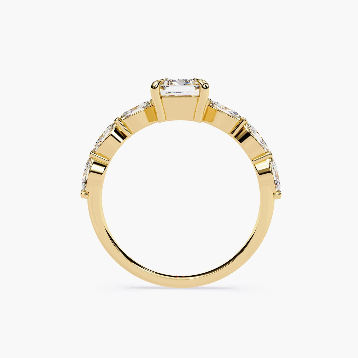 A yellow gold emerald-cut moissanite engagement ring. The ring features a large, radiant emerald-cut moissanite center stone.