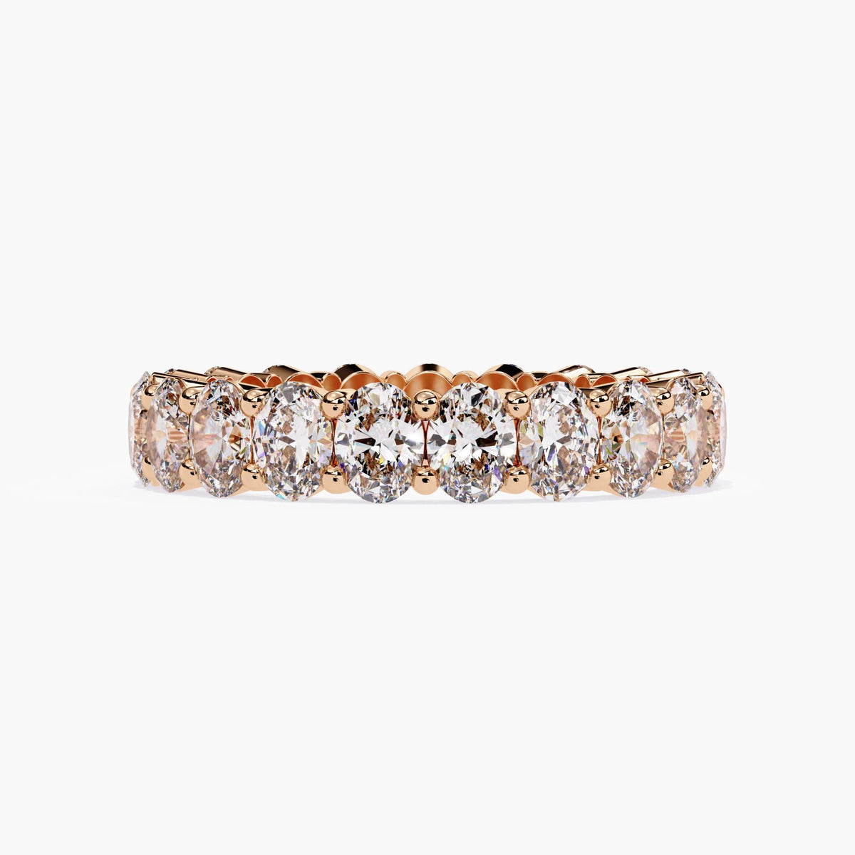 A rose gold band ring with a row of oval shaped diamonds set in a pave setting.