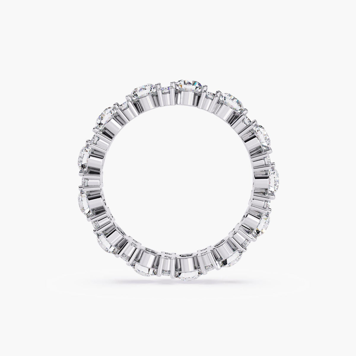 A white gold full eternity ring with round cut diamonds in different sizes.
