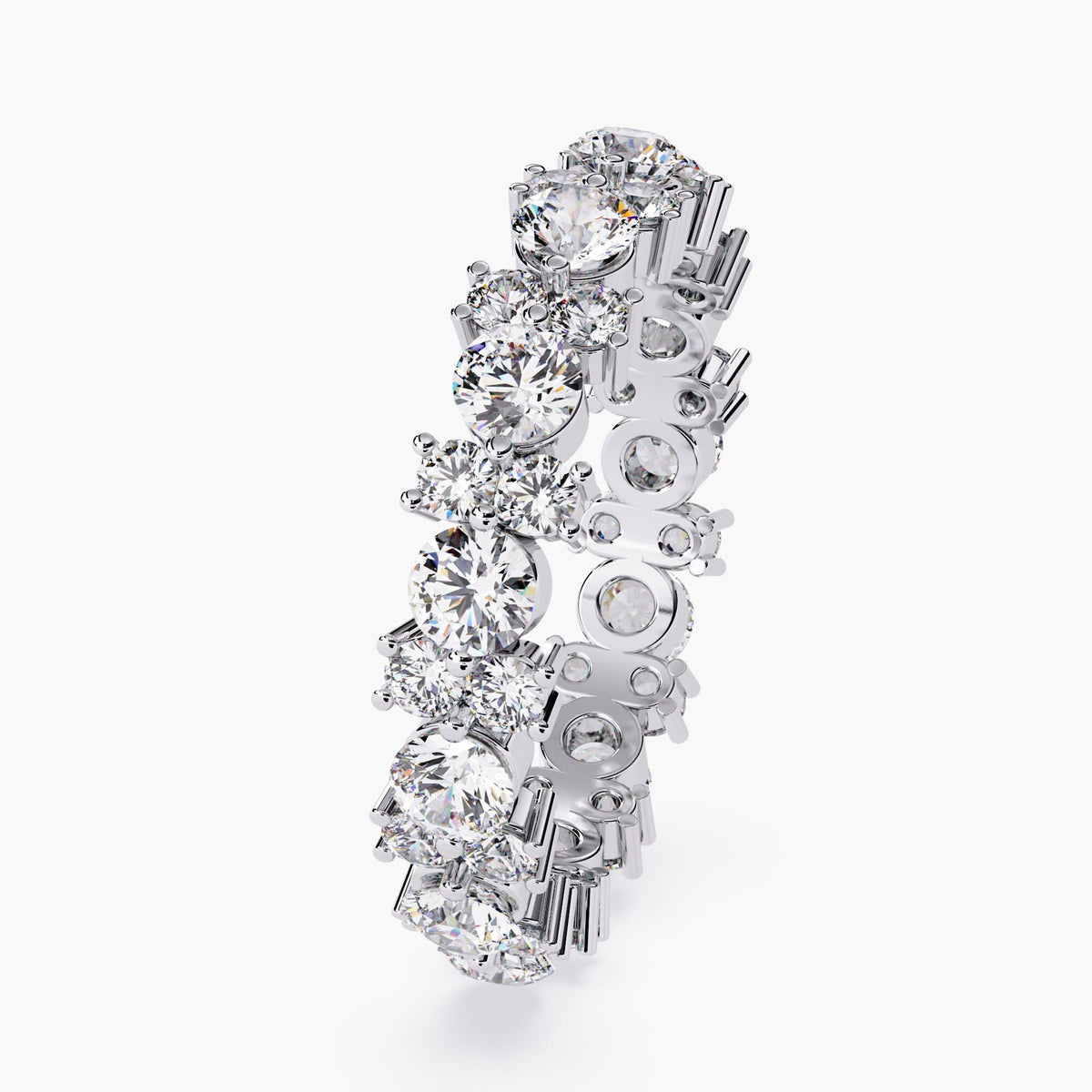 A white gold full eternity ring with round cut diamonds in different sizes.