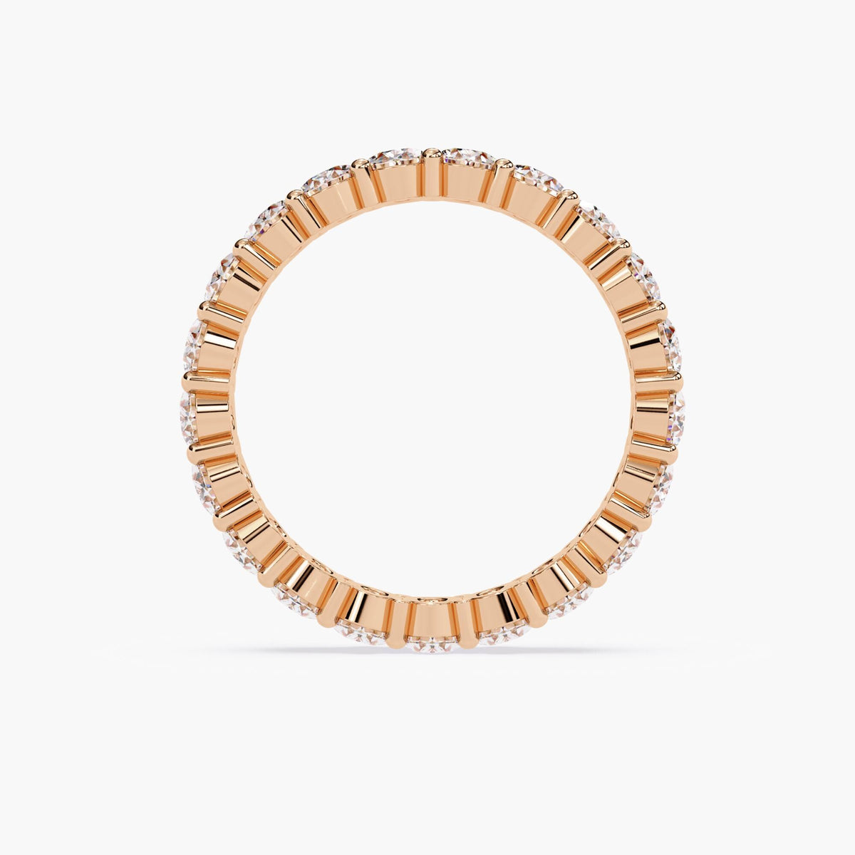 A rose gold band ring with a row of oval shaped diamonds set in a pave setting.