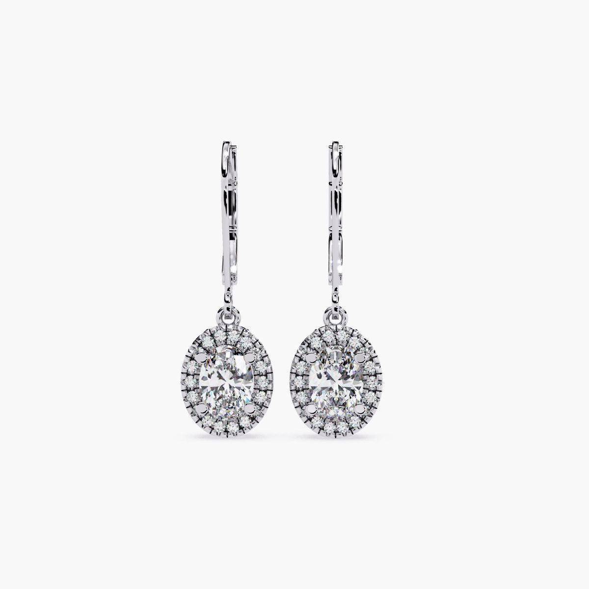A pair of 14K white gold leverback earrings with oval lab-grown center diamonds surrounded by a halo of round diamonds. The side view highlights a heart-shaped filigree gallery, adding vintage elegance to the drop design.