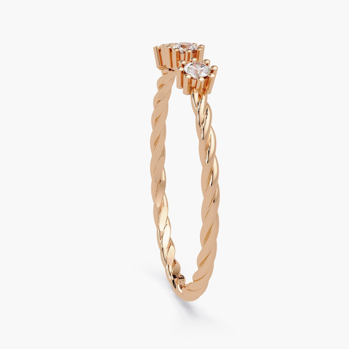 Side profile of a 14k rose gold twisted band ring showing the height of the three round natural diamonds in raised floral prong settings.