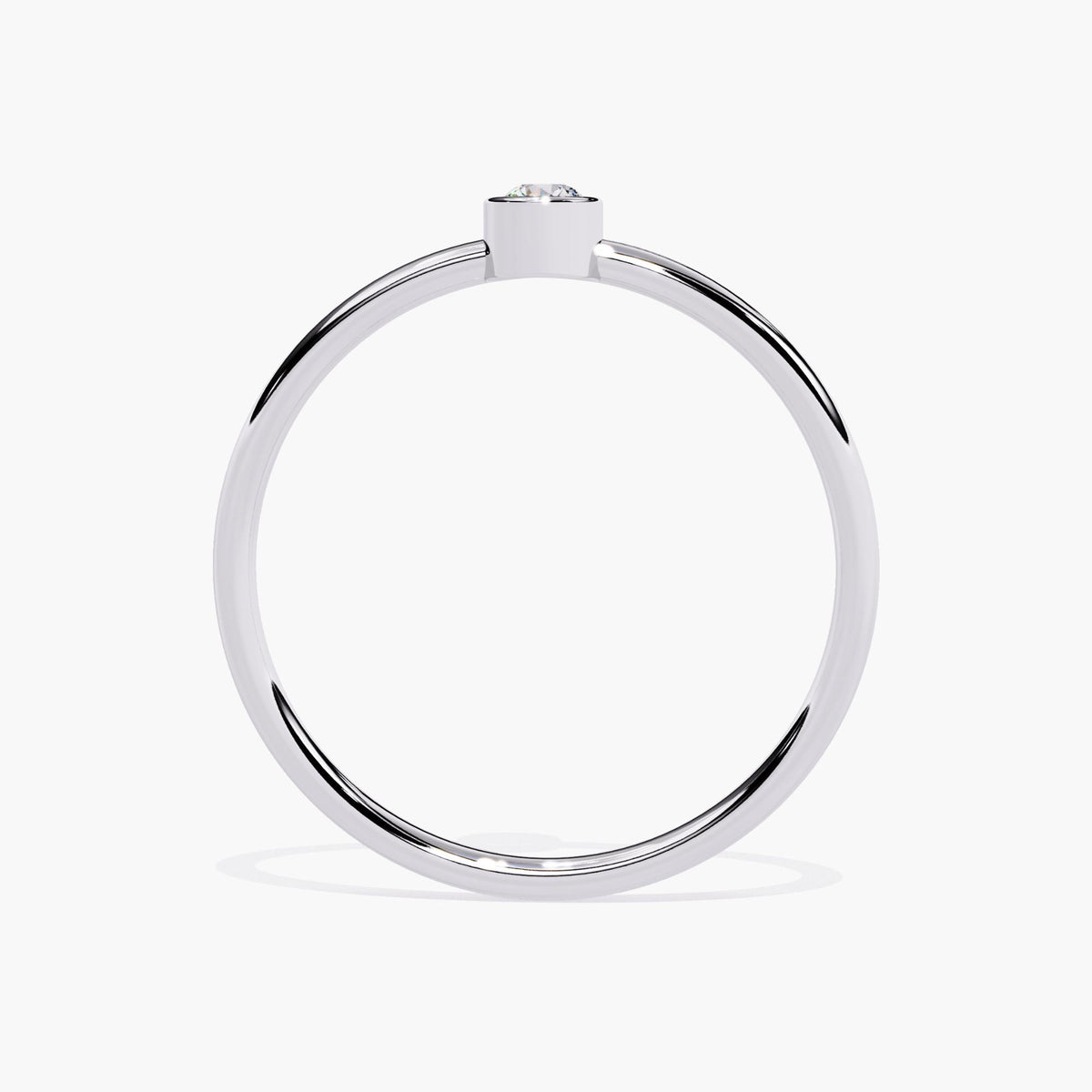 Side profile of a thin white gold bezel set solitaire ring, showing the low-set round natural diamond and delicate 1.3mm band thickness.