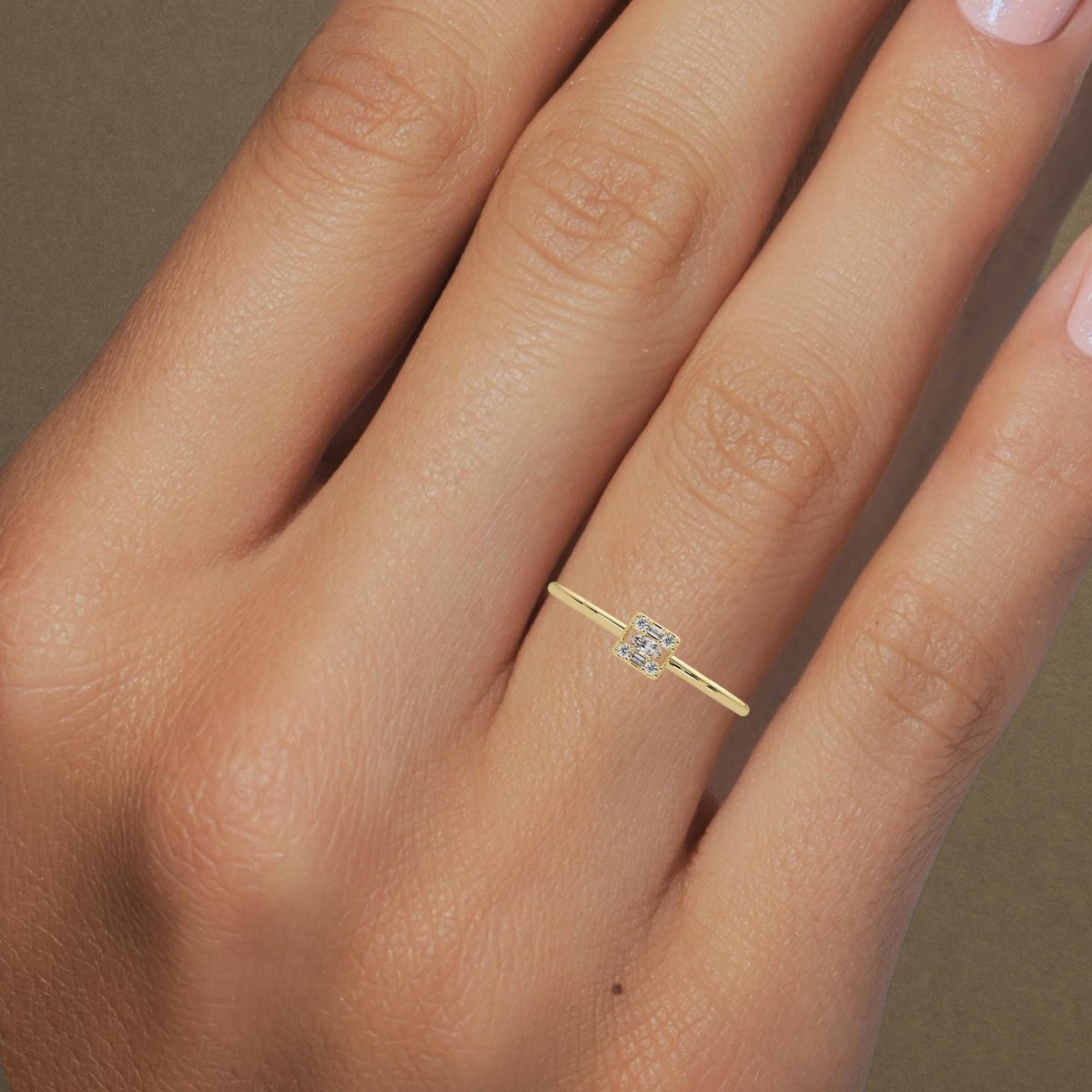 The ring worn on a finger to show scale and fit. its a dainty ring