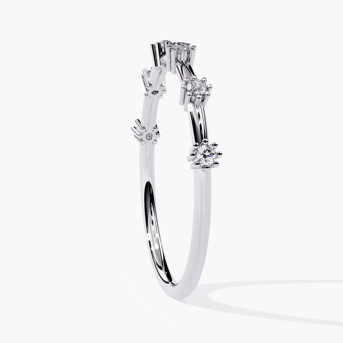 Side view of a 14k white gold diamond band with six round natural diamonds in spaced prong settings. The slim 1.3mm band curves gently, and the elevated 1.5mm diamonds appear to float above the band for a modern, airy look.