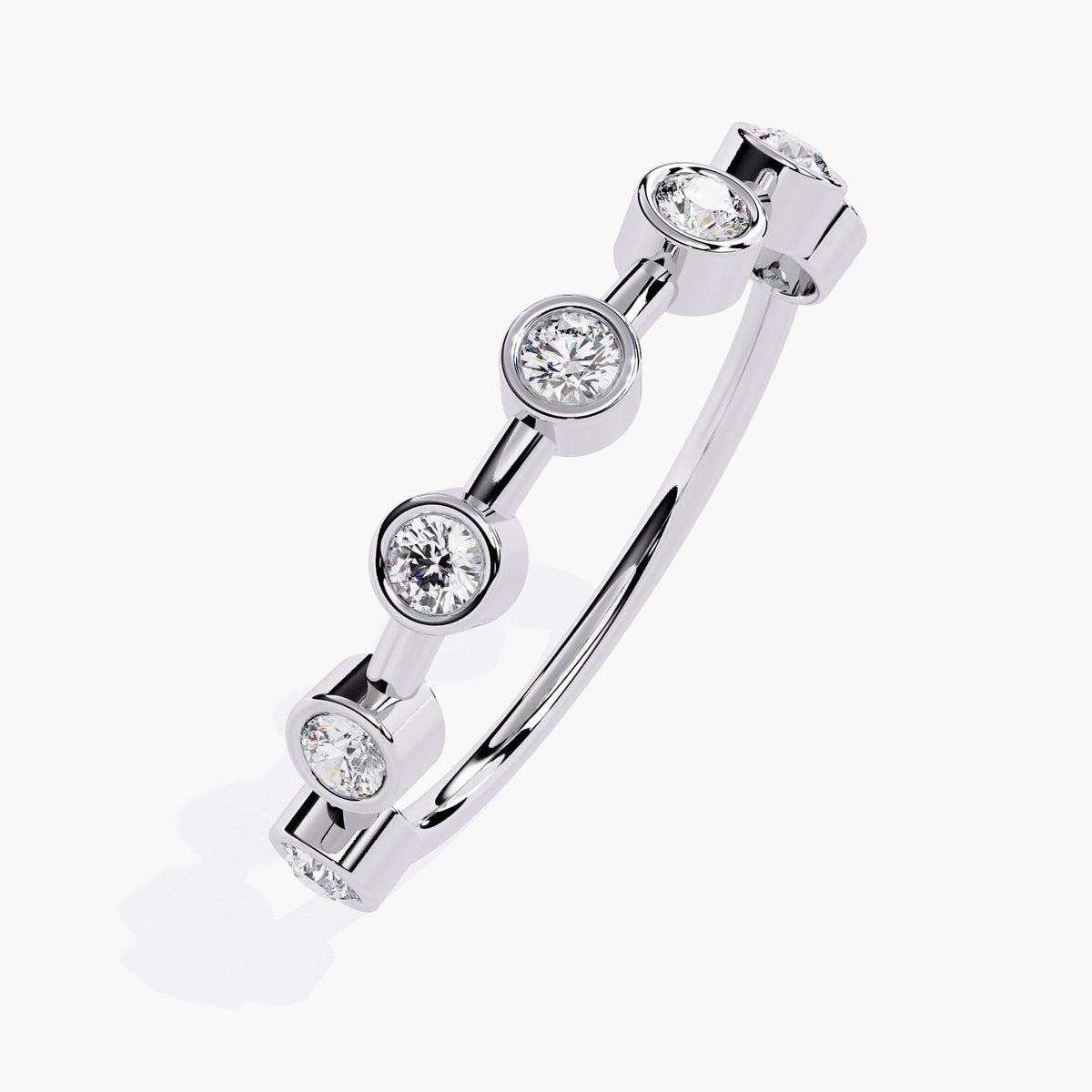 A white gold stacking ring featuring seven round lab-grown diamonds, each set in a sleek bezel setting. The diamonds, measuring 2.2mm each, are spaced evenly along the band, creating a minimalist, modern design. The ring stands 3mm high with a 1.3mm band thickness, offering a refined and contemporary look. Perfect for stacking or wearing alone, this elegant piece is ideal for those seeking a unique and timeless addition to their jewelry collection.