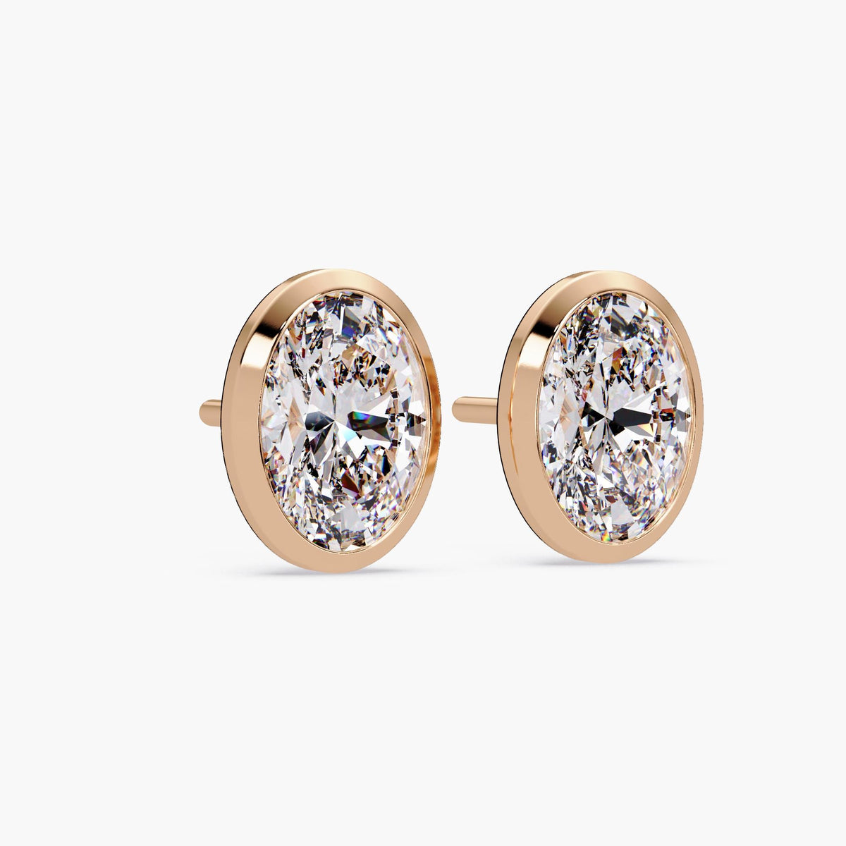 14k rose gold bezel set oval diamond stud earring, showcasing the low-profile open gallery and straight pushback post. Designed for secure and comfortable everyday wear.