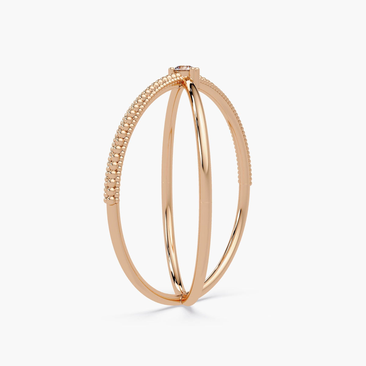 14k rose gold criss cross ring featuring a round natural diamond at the center, with one polished band crossing over a beaded gold band in an X-ring design.
