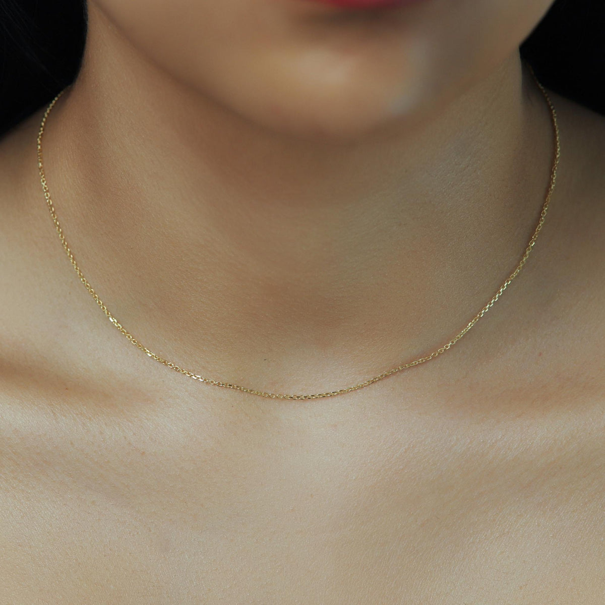 14K solid gold cable chain necklace worn on neck, featuring 0.9mm diamond-cut links with a soft shimmer, styled as a minimalist everyday gold chain