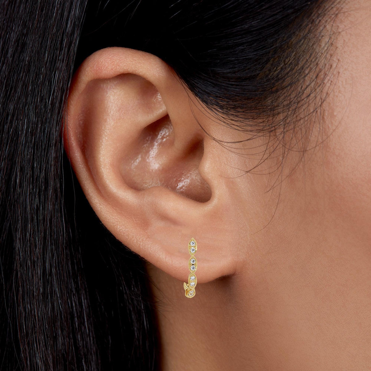 14K yellow gold marquise huggie hoop earring with pavé diamonds shown worn on ear for size reference and styling context.