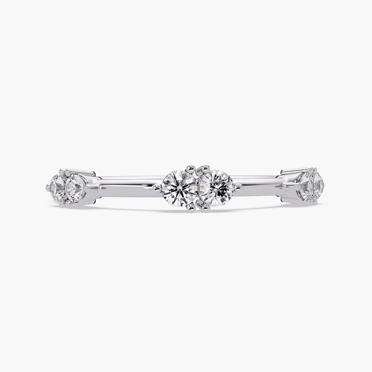 A dainty 14K white gold stacking ring featuring six natural round diamonds at distance. Each diamond is prong-set, evenly spaced along a slender, high-polish 1.3mm band. The ring is idea for everyday wear, gifting, or stacking.