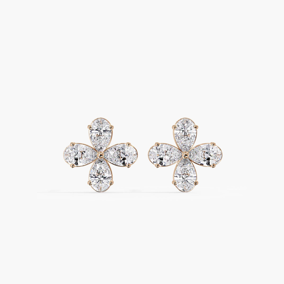 14K rose gold floral stud earrings featuring four lab-grown pear-shaped diamonds in each earring. The dainty cluster design creates a delicate flower shape, set in soft rose gold for a romantic, feminine look.