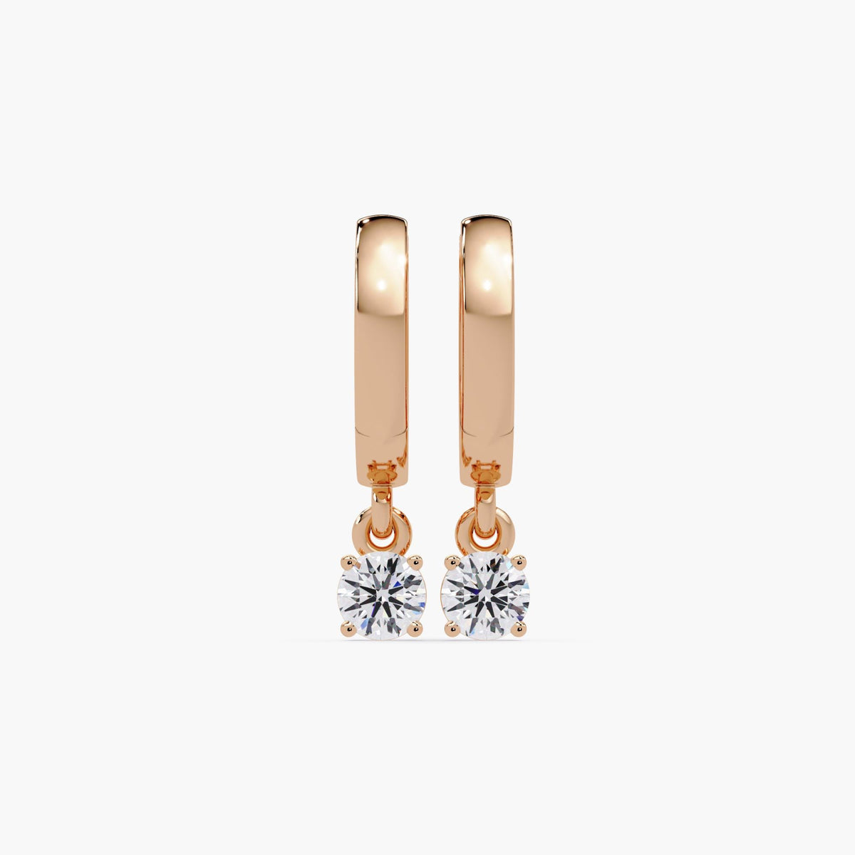 14K rose gold huggie earrings with round natural diamond drops in prong settings. Earrings feature a high-polish finish and secure hinged hoops.