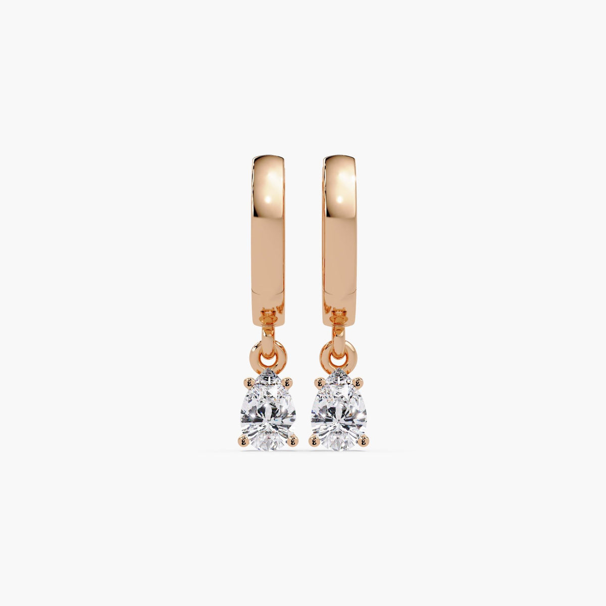 14K rose gold huggie earrings featuring pear-shaped lab-grown diamonds in prong settings. The diamonds dangle gently from polished hoops, showcasing a warm rose gold tone and brilliant sparkle.