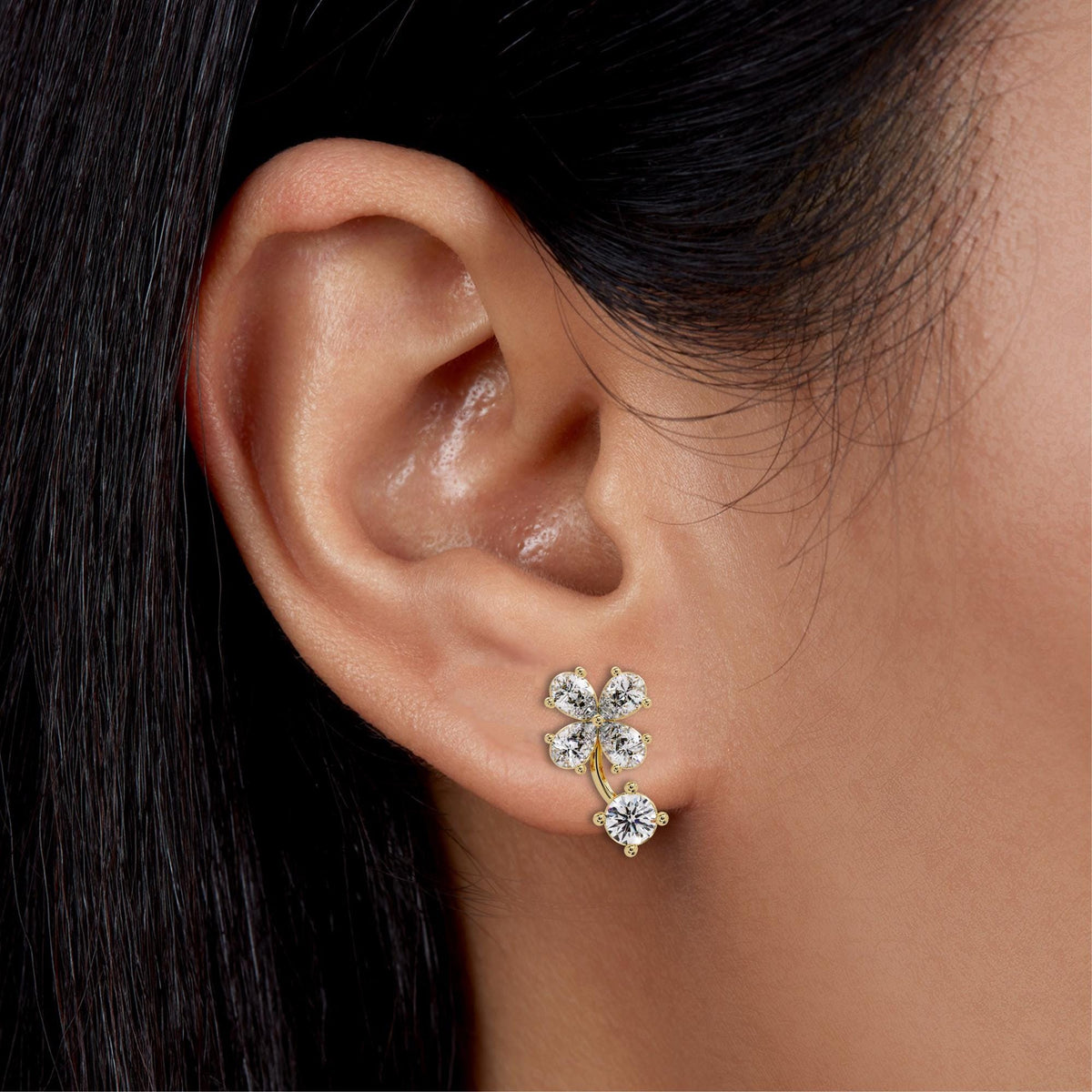 14K gold diamond floral studs featuring pear and round lab diamonds. The sculptural clover design curves naturally along the ear for a bold yet feminine look. Perfect for solo wear or bridal styling, these earrings frame the face with brilliant sparkle.