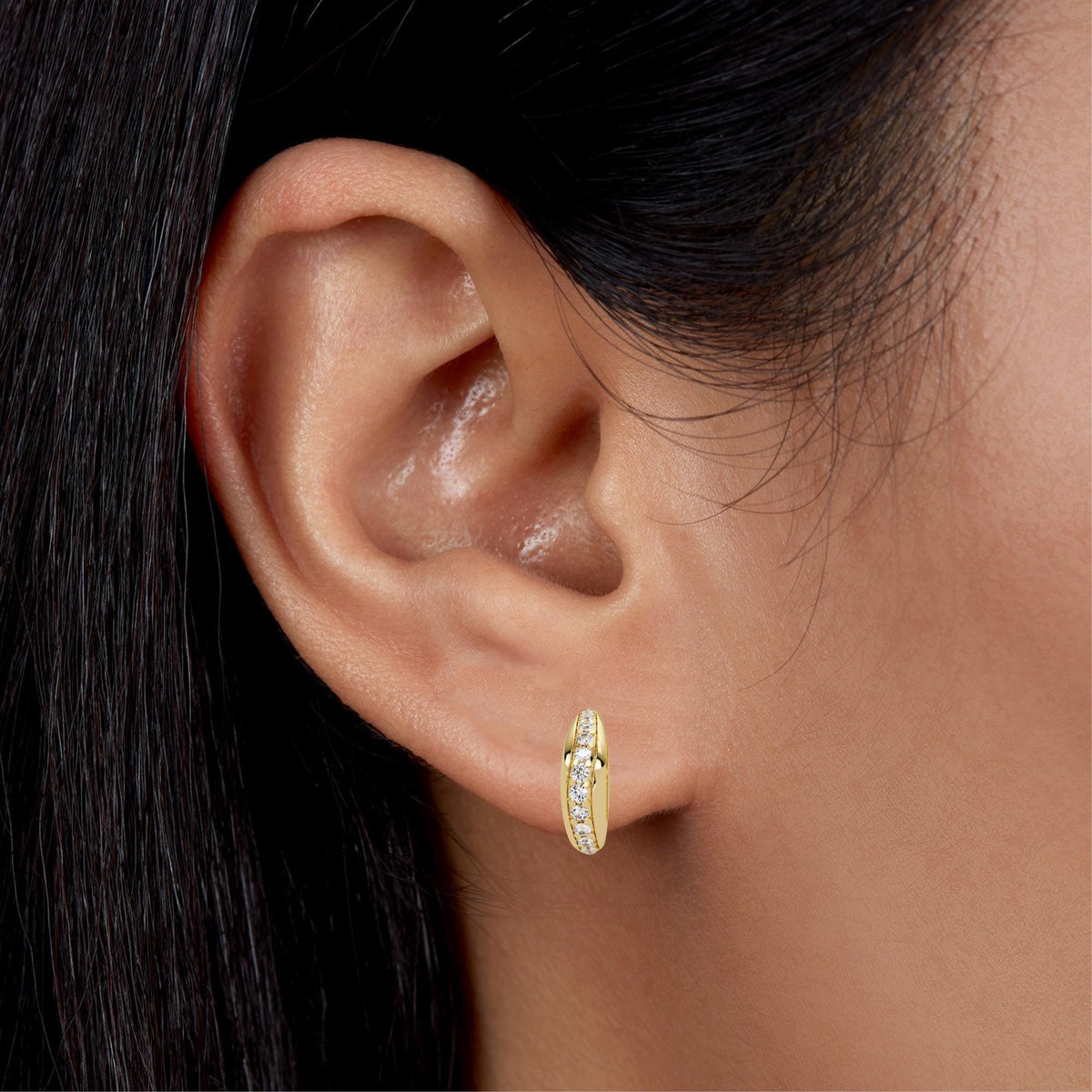 14K yellow gold dome huggie earring with natural diamonds worn on ear, chunky stud hoop style showcasing everyday gold hoops for women.