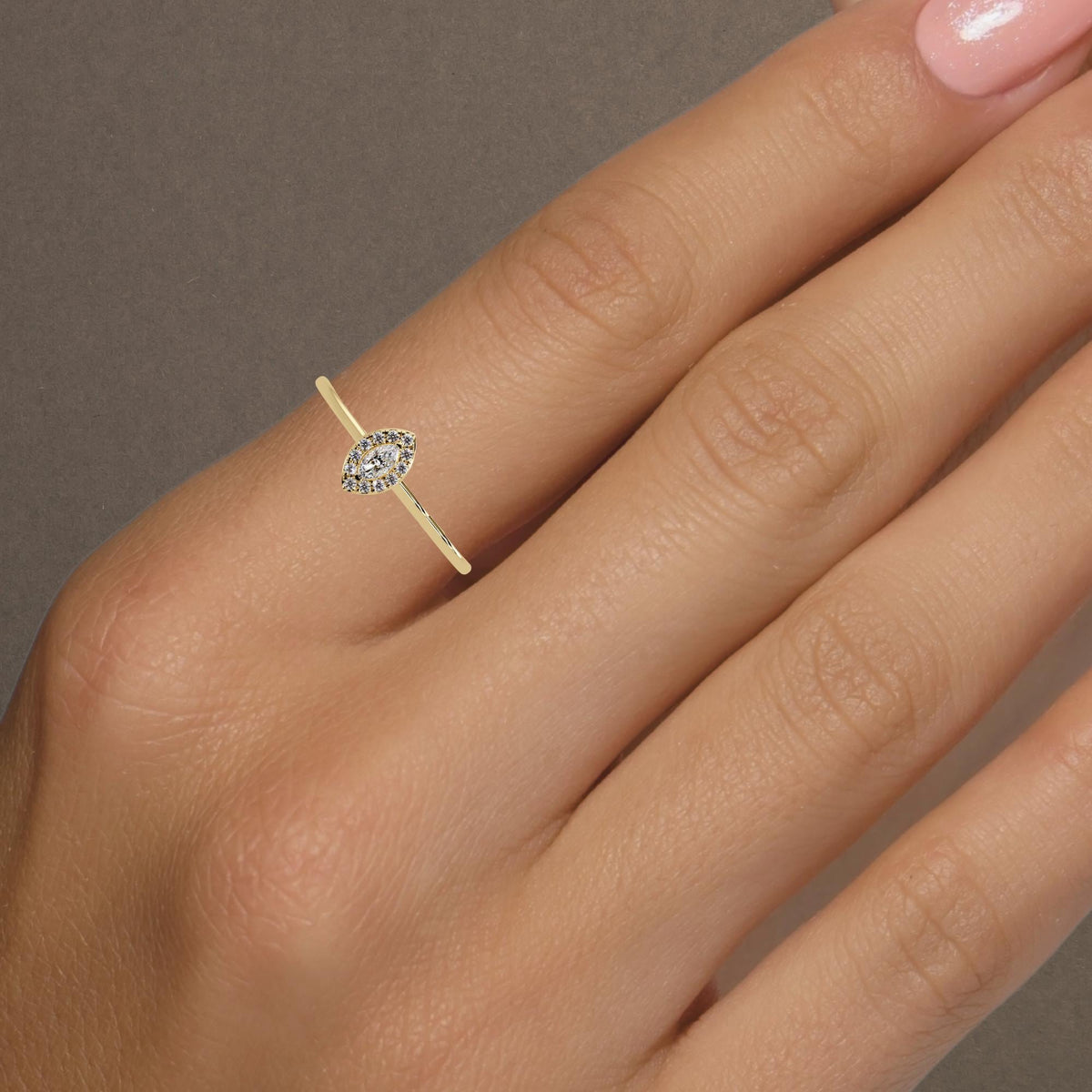 Dainty marquise halo diamond ring worn on index finger in 14K yellow gold, perfect for stacking, pinky ring, or everyday wear