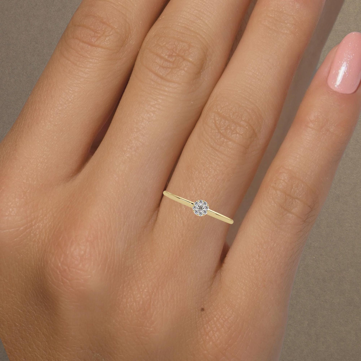 The thin solid gold band holdsThis minimalist gold ring makes a timeless promise ring or everyday jeweA classic solitaire-inspired diamond ring in 14K gold, perfect for gifting or proposals.