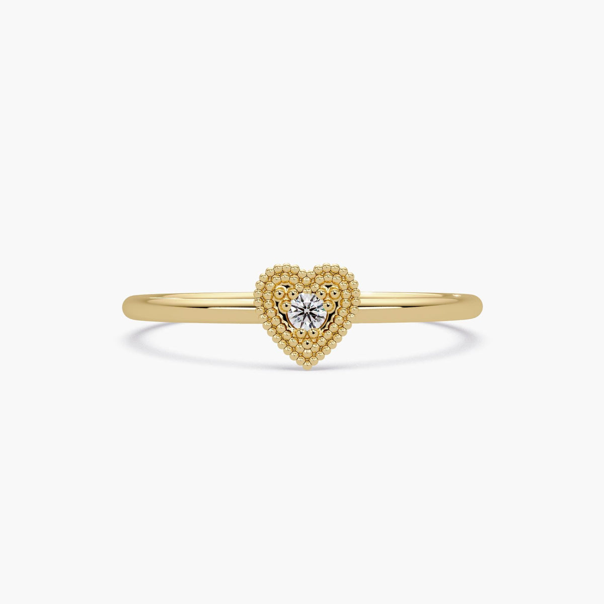 This is a dainty 14K yellow gold ring featuring a small beaded heart with a sparkling diamond in the center.