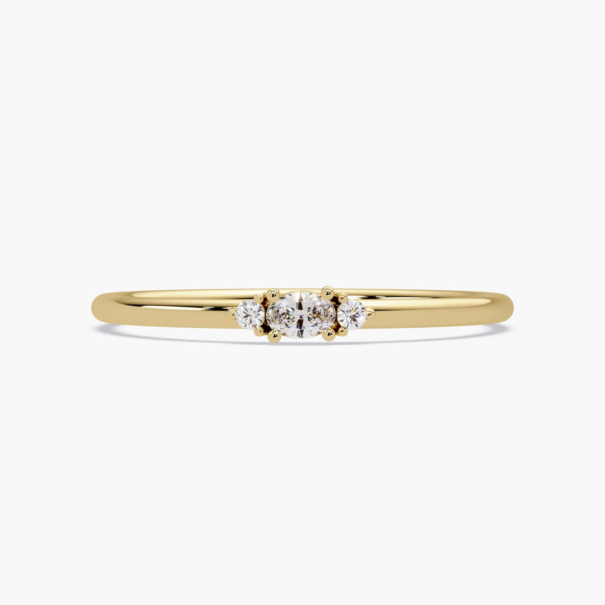 14K yellow gold diamond ring with a 3-stone setting — featuring a center oval-cut lab diamond flanked by two round diamonds on a slim 1.3mm band.