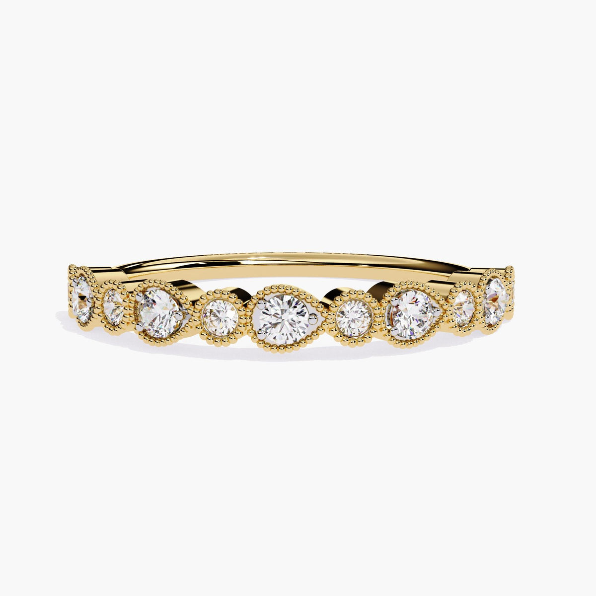 A yellow gold stackable half eternity band featuring alternating pear-shaped and round bezel settings, each with a round brilliant diamond. The diamonds are encircled by delicate milgrain detailing, creating a sophisticated and timeless design. This ring is perfect for stacking with other bands or wearing on its own.