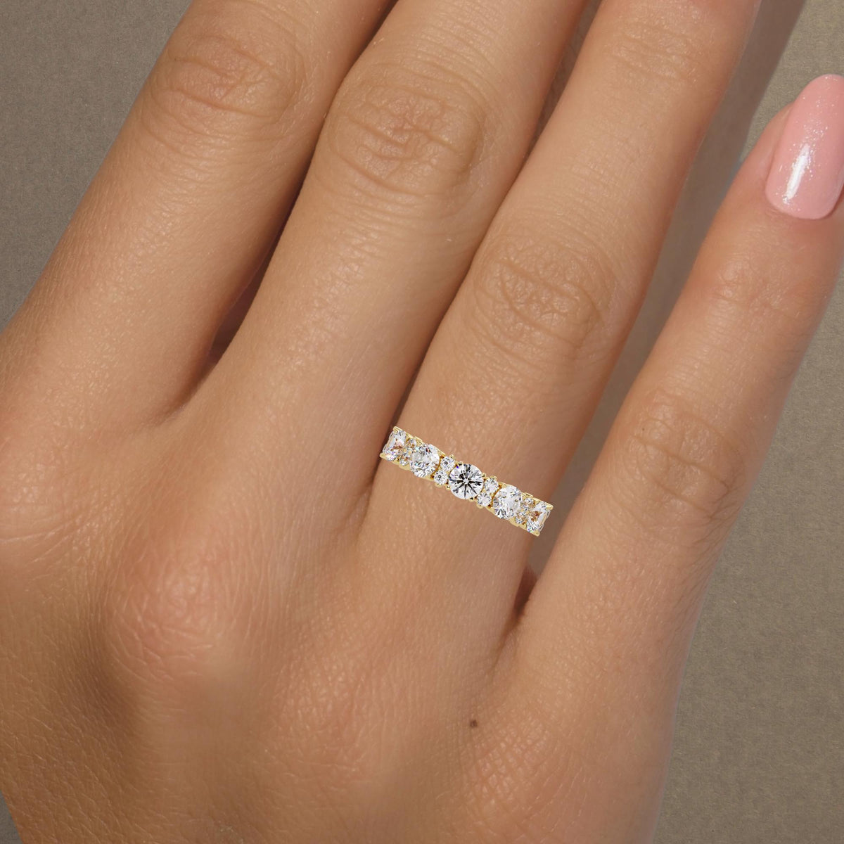 Round lab-grown diamond half eternity band worn on a woman’s hand, showing scale and sparkle in natural lighting.