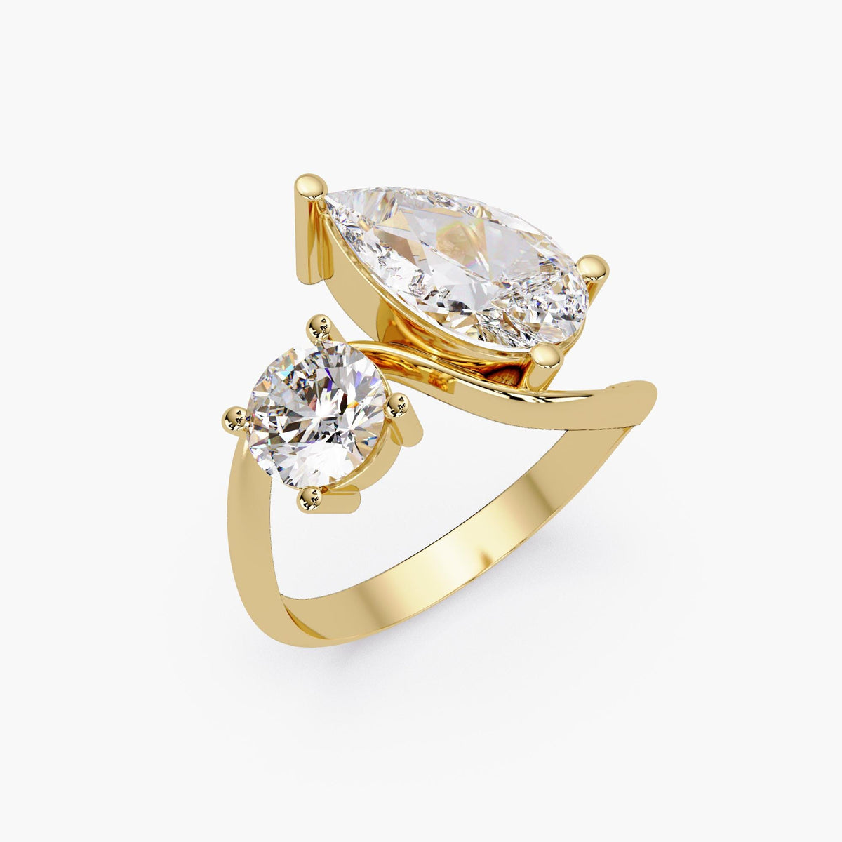 14k gold toi et moi ring with a pear diamond and round diamond in a bypass design.