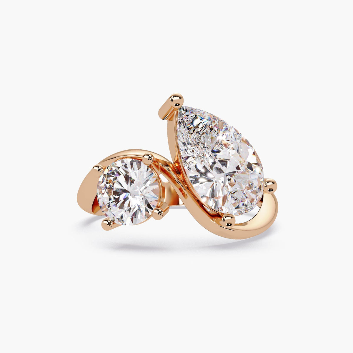 14k rose gold toi et moi ring with a pear diamond and round diamond in a bypass design.