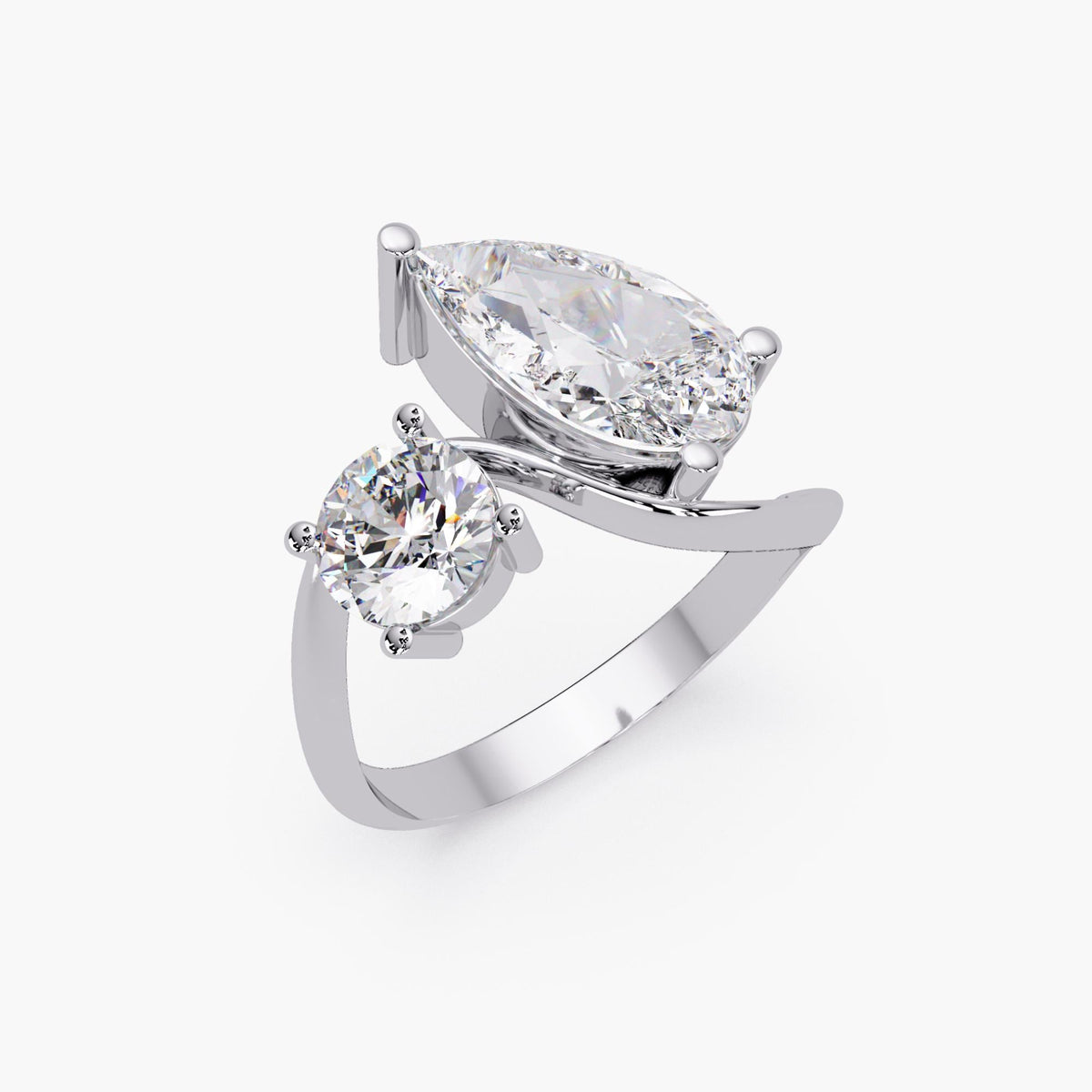 14k white gold toi et moi ring with a pear diamond and round diamond in a bypass design.