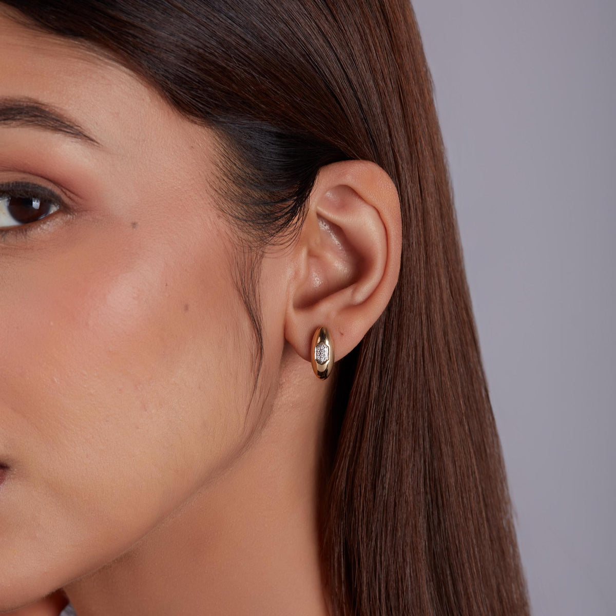 Modern gold stud earrings worn on ear, statement gold stud earrings with diamonds for everyday wear