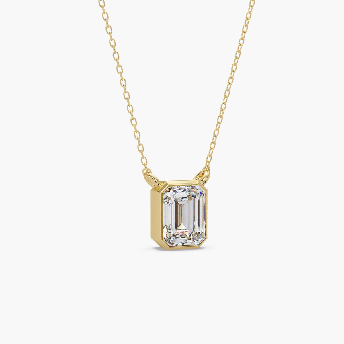 14K yellow gold emerald cut lab grown diamond bezel pendant necklace with a polished gold frame and fine cable chain.