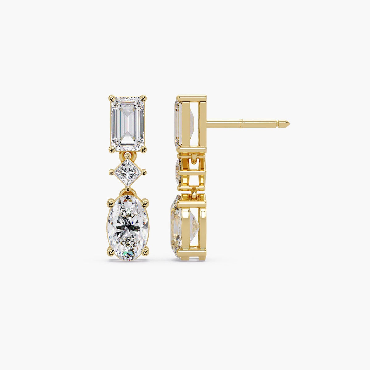 Oval and emerald cut lab grown diamond drop earrings in 14K gold, featuring a graduated three stone design with oval diamonds and emerald accents.