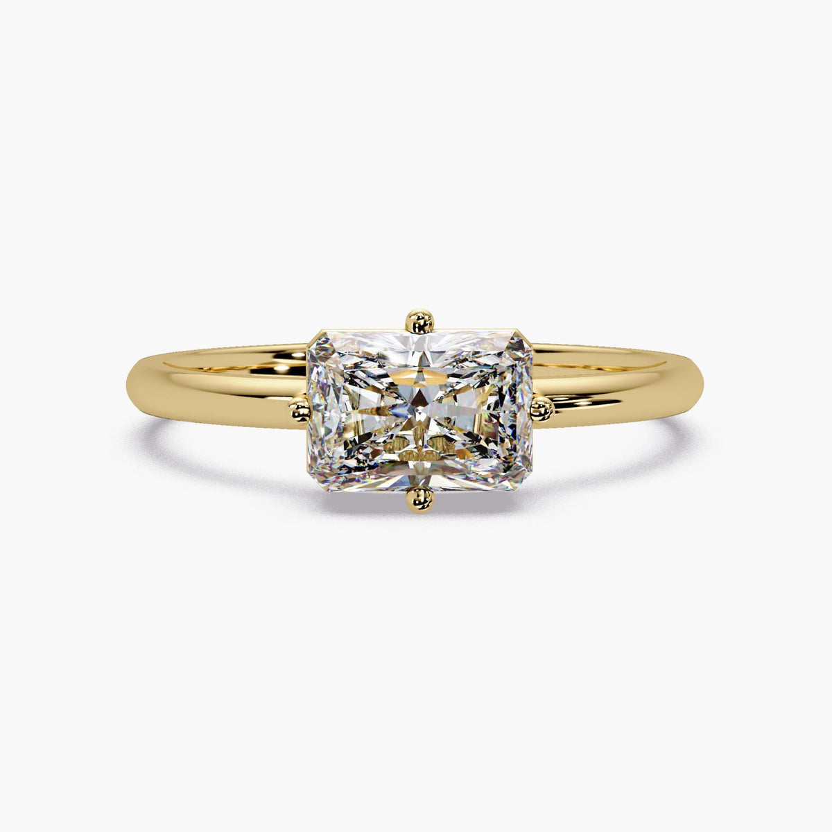 14K yellow gold solitaire ring featuring a 1.05CT radiant-cut lab-grown diamond. The horizontal "east-west" orientation offers a unique, sophisticated aesthetic designed for a modern engagement or a bold fashion statement.