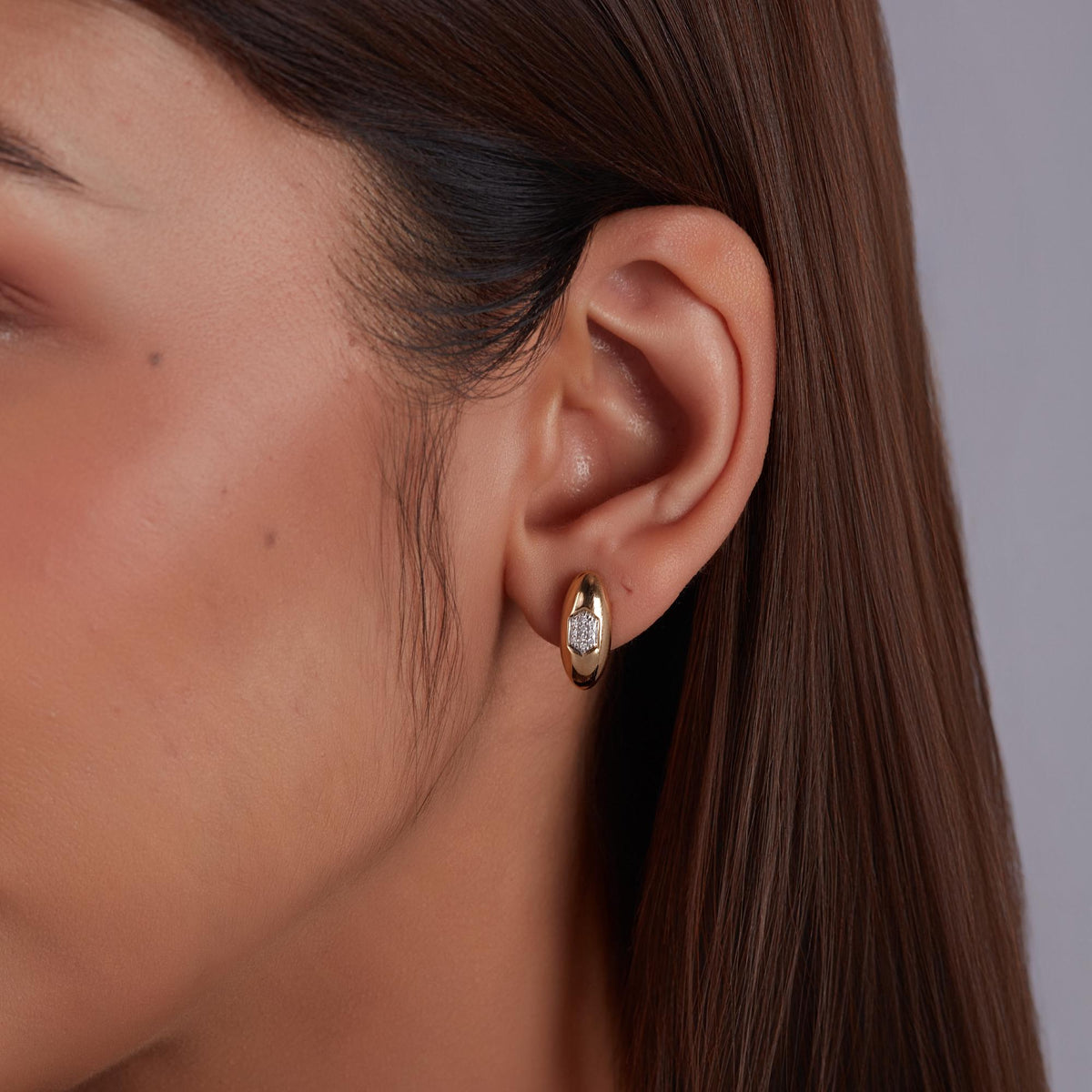 Natural diamond gold stud earrings featuring pavé diamond gold studs in an oval dome silhouette