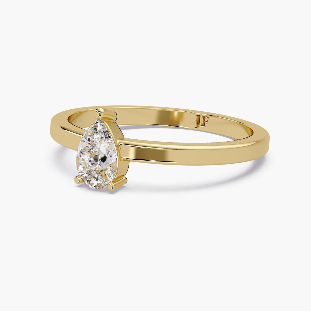 The yellow gold pear lab-grown diamond ring shown at an angle, highlighting the three-prong setting, polished band, and interior Jewel Frost mark.