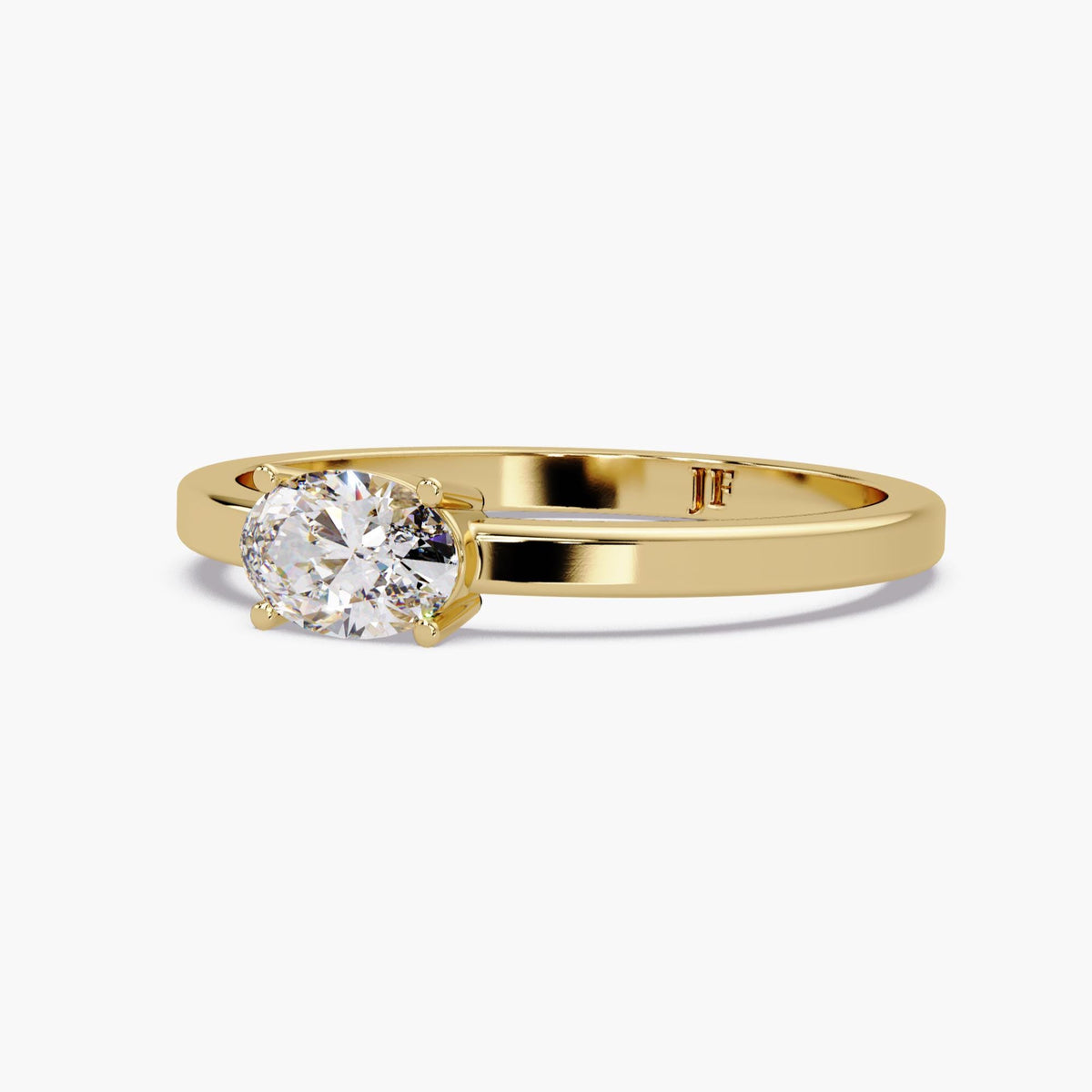 The oval lab-grown diamond solitaire ring shown at an angle, highlighting the four-prong setting, polished 14K yellow gold band, and interior Jewel Frost mark.
