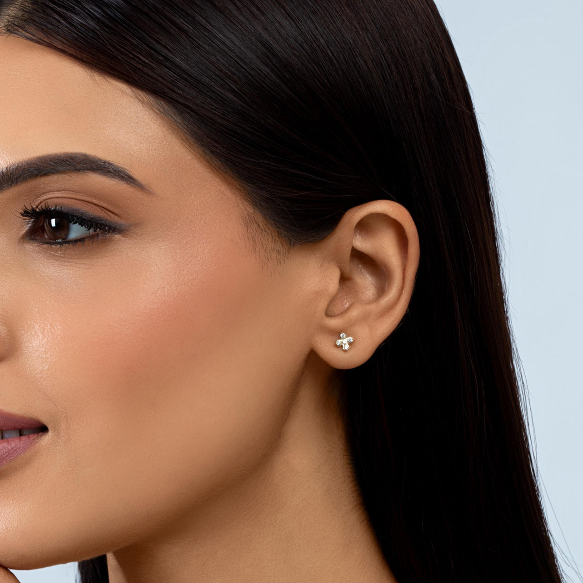 14K yellow gold geometric X stud earring with five round pavé-set lab-grown diamonds, worn on an ear.