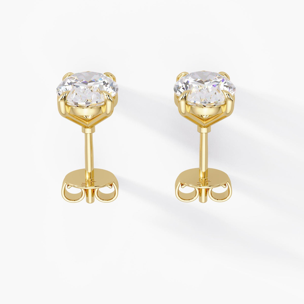 Oval lab-grown diamond stud earrings in 14K yellow gold with open four-claw basket settings, straight posts and butterfly pushback closures.