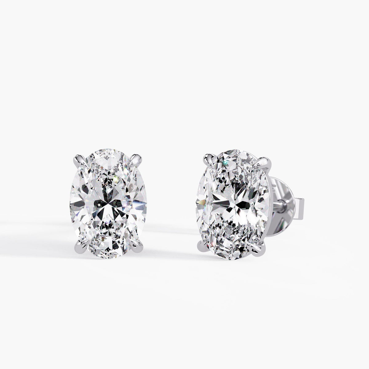 14K white gold oval lab-grown diamond studs with EF+ color, VVS/VS+ clarity, four-claw solitaire settings and pushback closures.